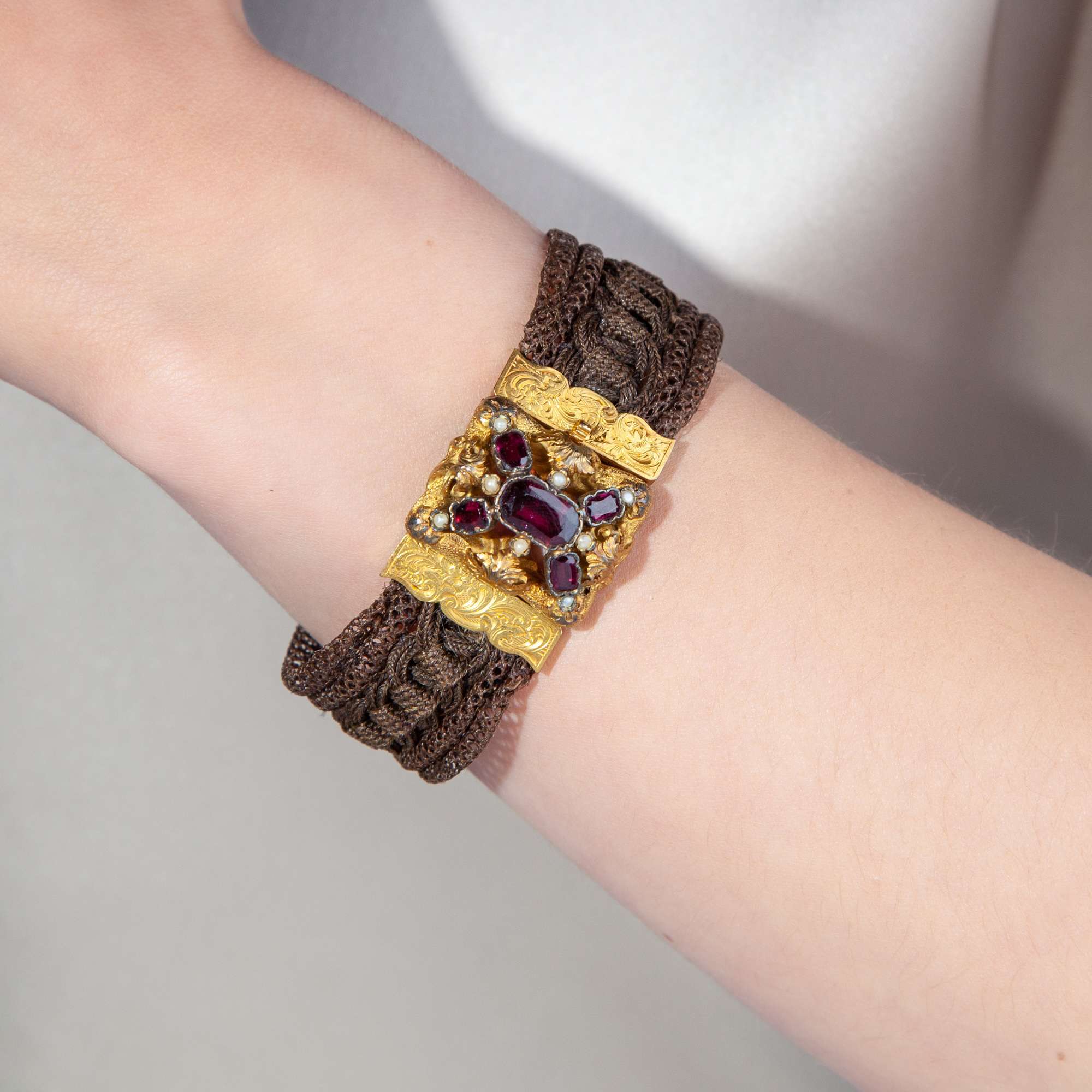 608297-hofer-antikschmuck-Antikes-Armband-aus-geflochtenem-Haar-Perlen-Gold-und-Granat-um-1850-Haare-fein-wie-gesponnenes-Gold